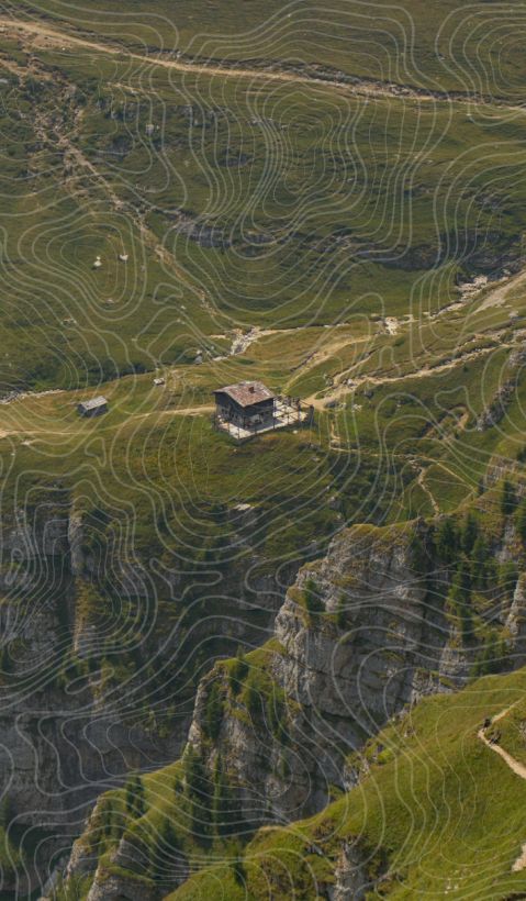 A house is photographed from a distance in the green Carpathian mountains.
