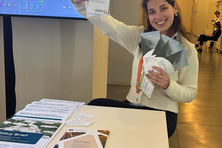 A young woman holding CoCo Flyer into the camera. 